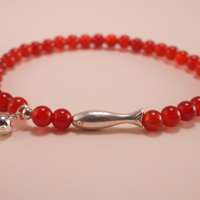 Close-up of red agate 4mm beads and sterling silver accents on energy bracelet