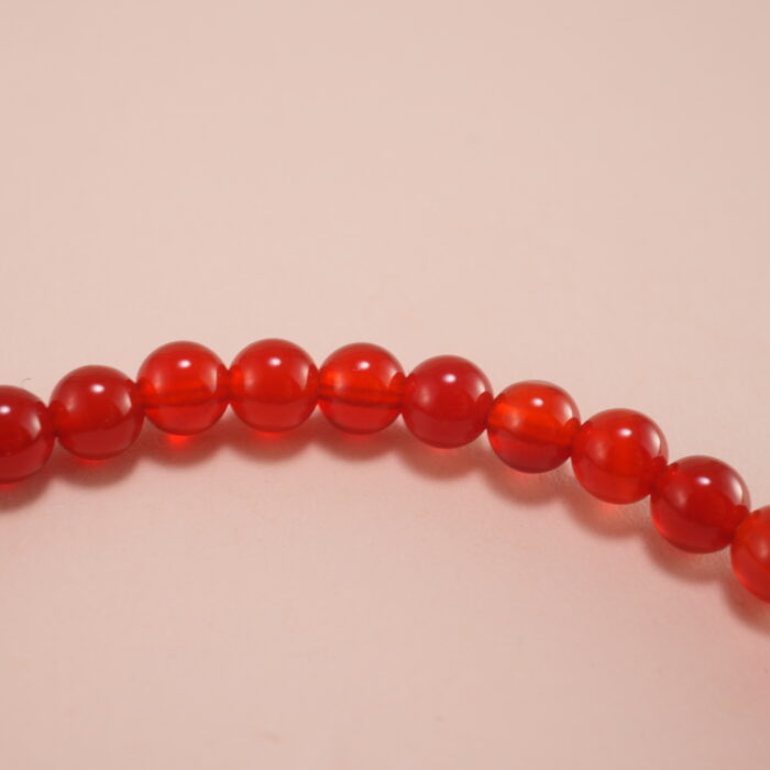 Close-up of red agate 4mm beads and sterling silver accents on energy bracelet