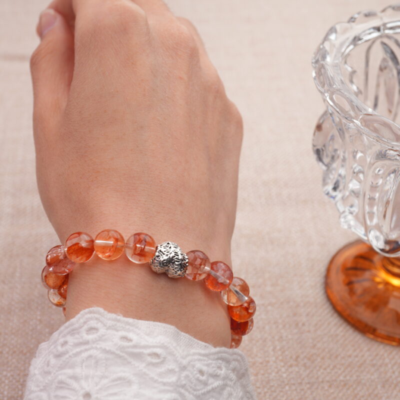 Woman wearing heart-shaped red opal bracelet – bold and elegant natural stone accessory
