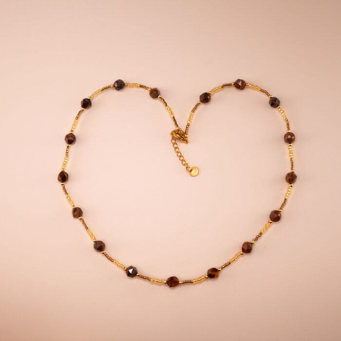 Handmade faceted tiger eye bead chain necklace on plain background