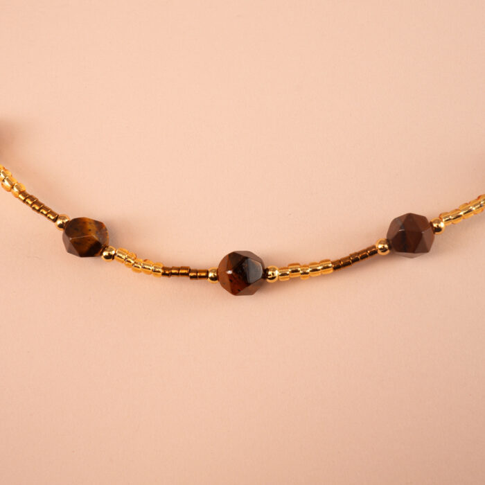 Close-up of faceted tiger eye gemstone beads in a continuous chain