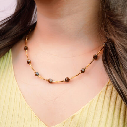 Model wearing faceted tiger eye bead chain necklace, highlighting reflective facets