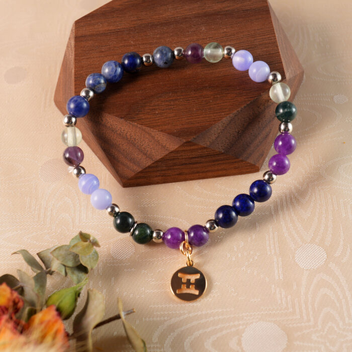 Gemini gemstone bracelet resting on natural wood surface for calming and expressive energy