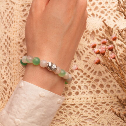 Hand wearing the heart-shaped agate bracelet, showing its elegant fit and warm tone against the skin.
