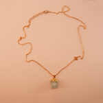 Handmade green fluorite pendant necklace on a neutral background
