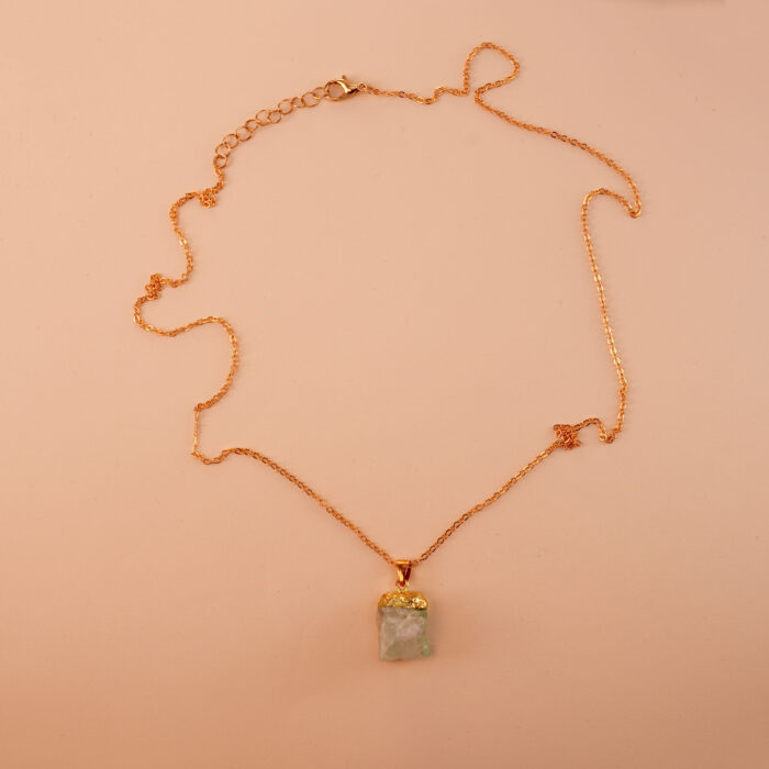 Handmade green fluorite pendant necklace on a neutral background