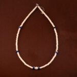 Handmade lapis lazuli, pearl, and white chalcedony necklace on neutral or soft fabric
