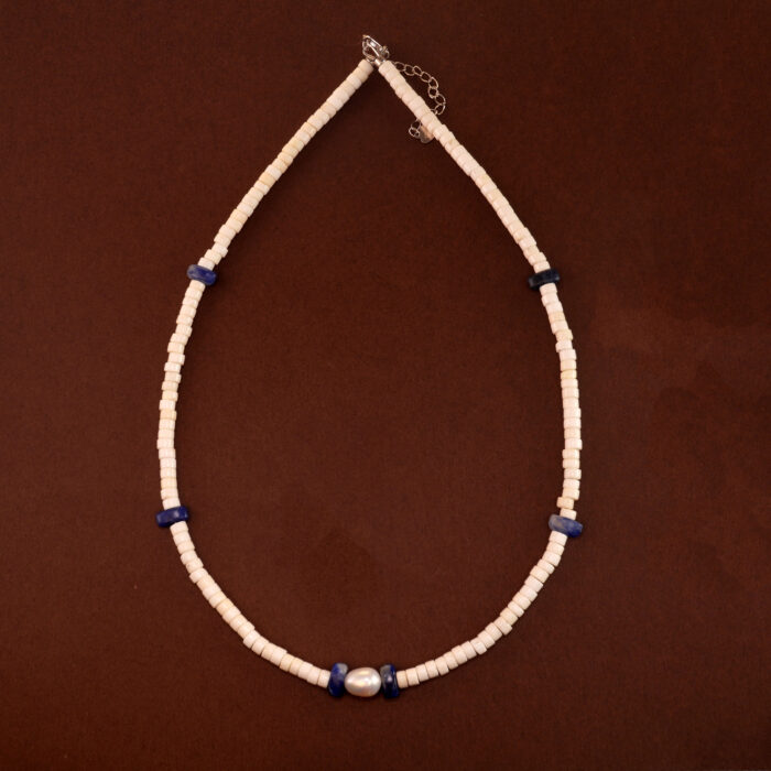 Handmade lapis lazuli, pearl, and white chalcedony necklace on neutral or soft fabric