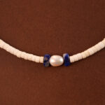 Close-up of round pearls, deep blue lapis, and translucent chalcedony beads
