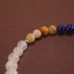 Close-up view of polished 4mm beads in deep blue, white, and pale green