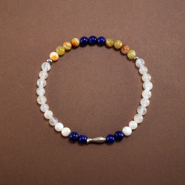Lapis lazuli and chalcedony bracelet with sterling silver charm on white background
