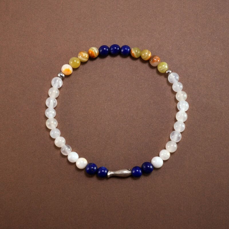 Lapis lazuli and chalcedony bracelet with sterling silver charm on white background