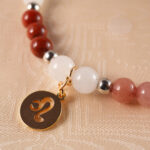 Detailed view of red jasper, crazy lace agate, strawberry quartz, and tiger eye beads highlighting texture and color