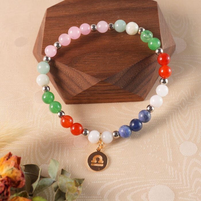 Libra crystal bracelet displayed on a natural wooden surface, representing peace and harmony