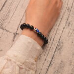 Wearing Blue Tiger Eye Bracelet with Silver Fish Charm – 8mm Crystal Jewelry for Calm and Strength