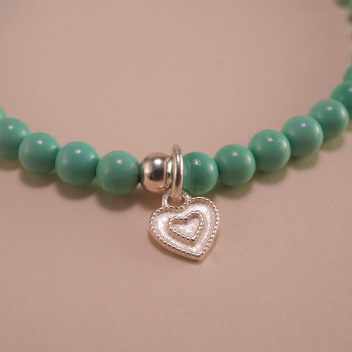 Close-up of turquoise, agate beads, and heart charm
