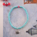 Turquoise and rhodochrosite bracelet placed on natural stone background with soft light