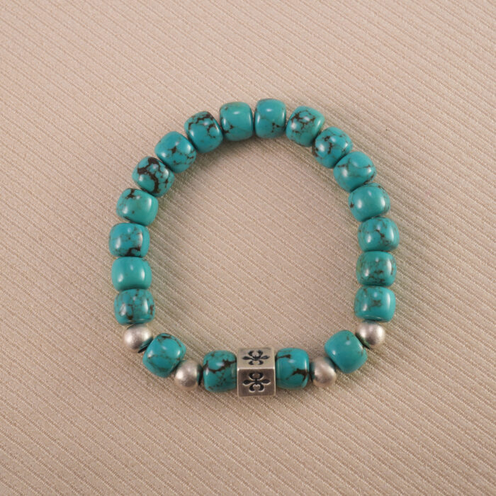 Close-up of an 8mm turquoise gemstone birthstone bracelet on white background