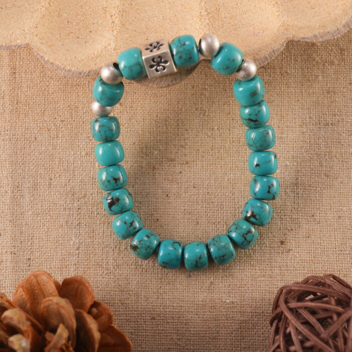 Turquoise birthstone bracelet placed on linen fabric with crystals and soft lighting