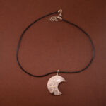 Handmade moon pendant necklace with clear quartz crystal on white background