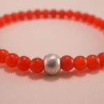 Close-up of small 4mm carnelian and red agate beads with sterling silver accents