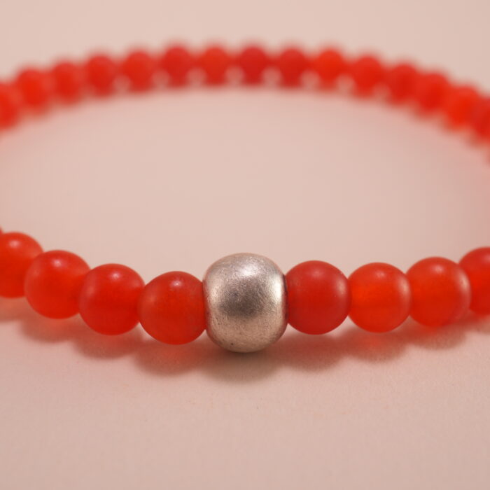 Close-up of small 4mm carnelian and red agate beads with sterling silver accents