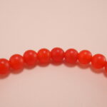 Close-up of small 4mm carnelian and red agate beads with sterling silver accents