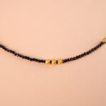 Close-up of polished black obsidian pendant on a gold-plated chain