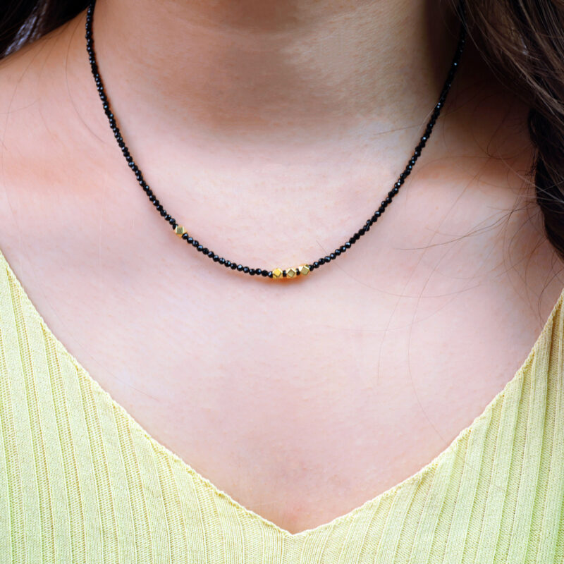 Model wearing handmade obsidian necklace, pendant resting on upper chest