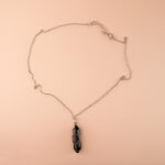 Handmade black obsidian point pendant necklace on white background