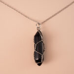 Close-up of pillar-shaped obsidian crystal pendant with silver loop