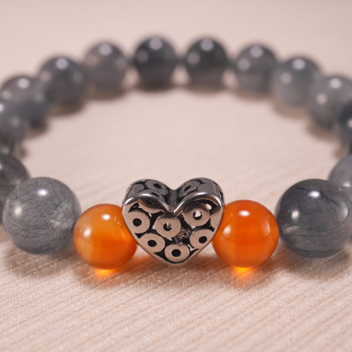 Close-up of gray agate and rutile quartz beads, showing clarity and inclusions.