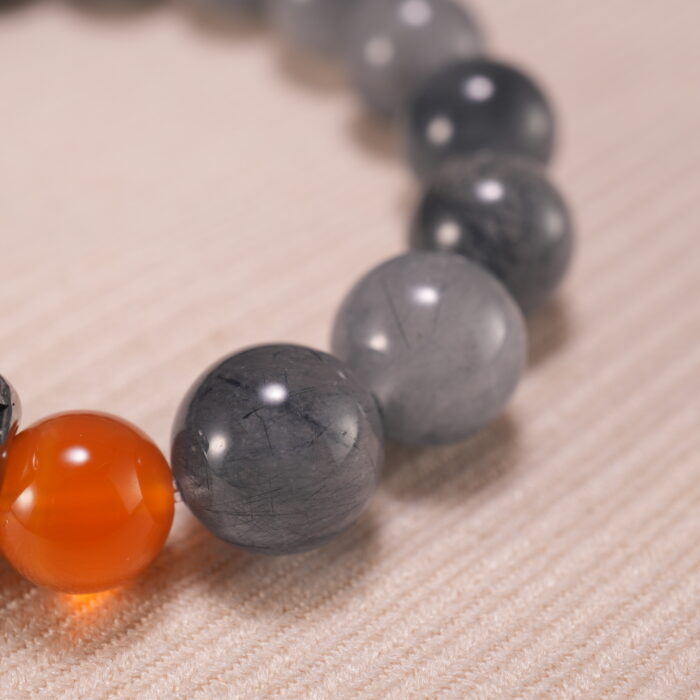 Close-up of gray agate and rutile quartz beads, showing clarity and inclusions.