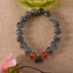 Bracelet resting beside flowers, representing calm energy and grounding.