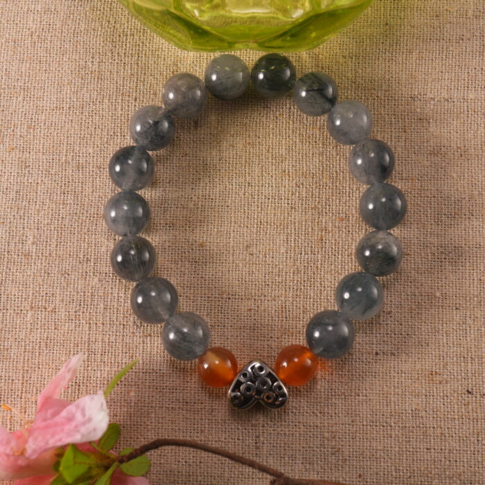 Bracelet resting beside flowers, representing calm energy and grounding.