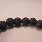 Close-up of lava bead texture and owl charm detail.