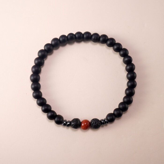 Matte black obsidian and cinnabar bracelet on white background with clean layout
