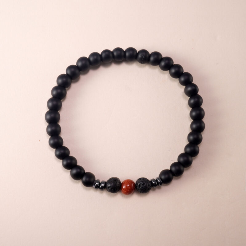 Matte black obsidian and cinnabar bracelet on white background with clean layout