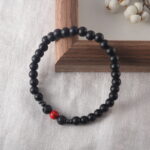 Bracelet resting on natural wood surface under soft natural light, evoking protection and energy