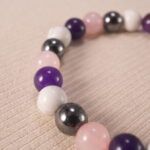 Close-up of 8mm obsidian, amethyst, and howlite beads, showing natural texture and polish.