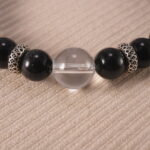 Close-up view of polished obsidian and clear quartz beads