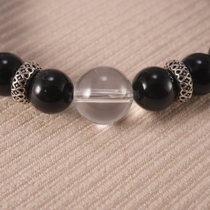 Close-up view of polished obsidian and clear quartz beads