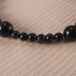 Close-up view of polished obsidian and clear quartz beads