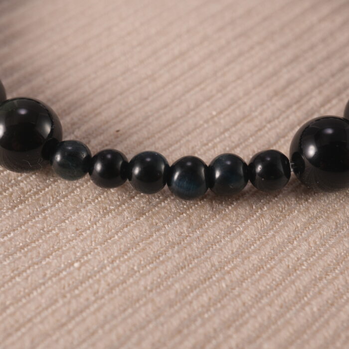 Close-up view of polished obsidian and clear quartz beads