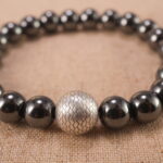 Close-up of natural stone beads with silver accents and smooth finish