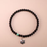Obsidian and turquoise 4mm bracelet with gold clasp and silver charm displayed on white background