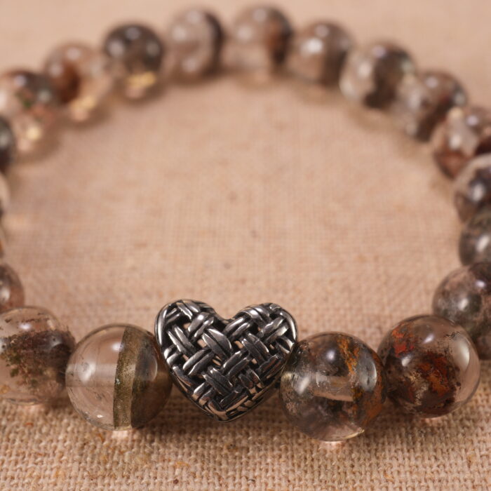 Close-up of translucent Phantom Quartz beads and S925 silver charm in heart-shaped detail