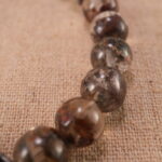 Close-up of translucent Phantom Quartz beads and S925 silver charm in heart-shaped detail