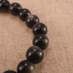 Close-up of polished obsidian beads and sterling silver clasp