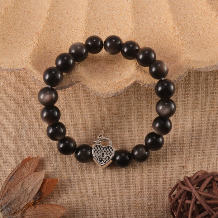 Obsidian bracelet placed on a stone surface in soft natural light